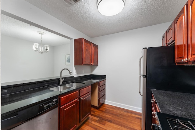 2041 Dixie Belle Dr Unit 2041C, Orlando, FL 32812 - kitchen with stainless steel appliances, dark brown cabinets, dark wood-style floors, dark countertops, and a chandelier