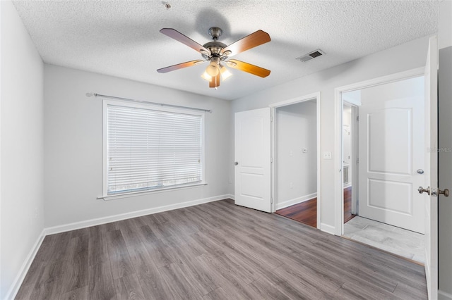 2041 Dixie Belle Dr Unit 2041C, Orlando, FL 32812 - unfurnished bedroom with wood finished floors, a textured ceiling, and a ceiling fan