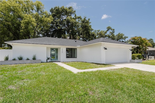 3920 Basswood Dr, Sarasota, FL 34232 - view of front of property featuring an attached garage, driveway, a front lawn, and stucco siding