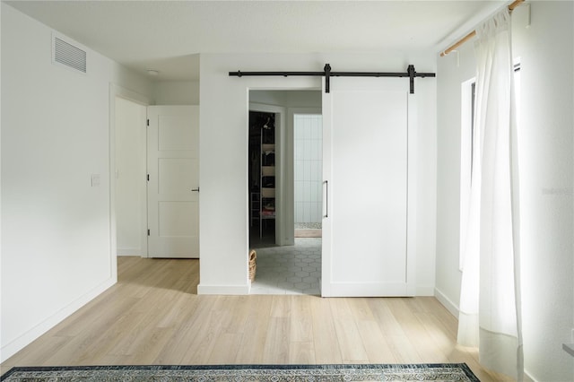 3920 Basswood Dr, Sarasota, FL 34232 - unfurnished bedroom featuring wood finished floors and a barn door