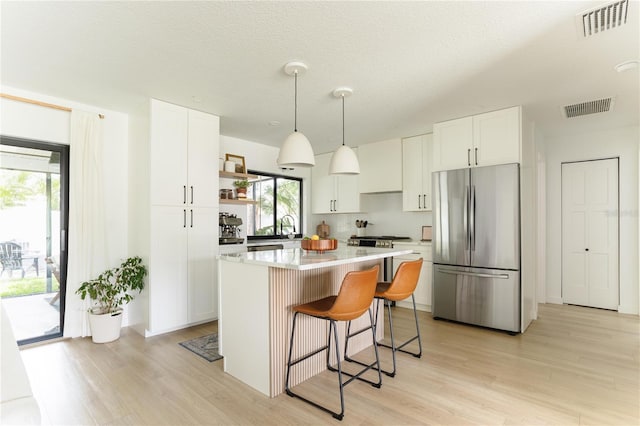 3920 Basswood Dr, Sarasota, FL 34232 - kitchen featuring freestanding refrigerator, open shelves, light wood-type flooring, and a kitchen island