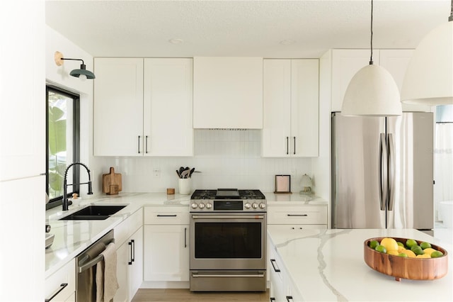 3920 Basswood Dr, Sarasota, FL 34232 - kitchen featuring stainless steel appliances, white cabinets, light stone counters, custom range hood, and a textured ceiling