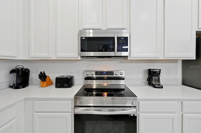 4429 Ganesha Loop, Kissimmee, FL 34746 - kitchen with stainless steel appliances, white cabinets, and light countertops