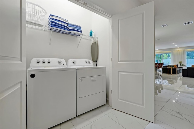 4429 Ganesha Loop, Kissimmee, FL 34746 - laundry area with washer and clothes dryer and light marble finish flooring