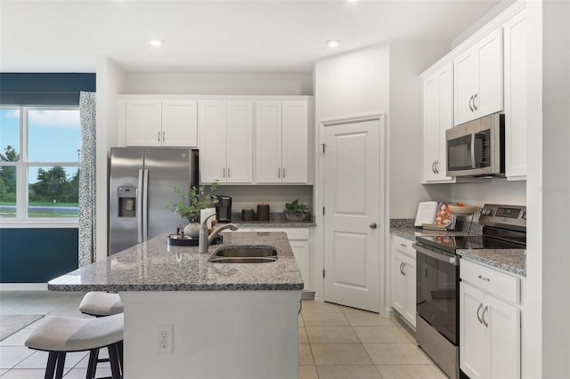 3220 Viridian Cir, West Melbourne, FL 32904 - kitchen featuring stainless steel appliances, white cabinetry, a breakfast bar area, light tile patterned flooring, and recessed lighting