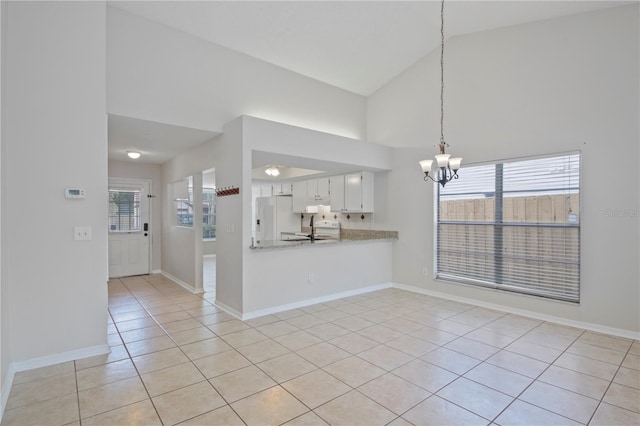1026 Mccully Ct, Oviedo, FL 32765 - kitchen with white appliances, light tile patterned flooring, a chandelier, light countertops, and plenty of natural light