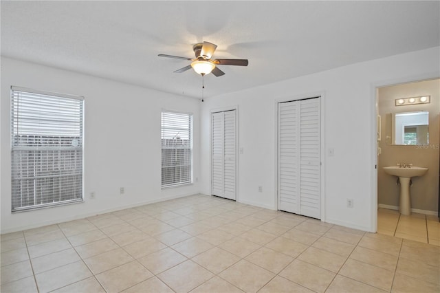 1026 Mccully Ct, Oviedo, FL 32765 - unfurnished bedroom featuring two closets, light tile patterned floors, connected bathroom, and a ceiling fan