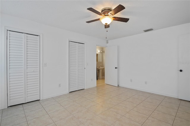 1026 Mccully Ct, Oviedo, FL 32765 - unfurnished bedroom with two closets, light tile patterned flooring, and ceiling fan