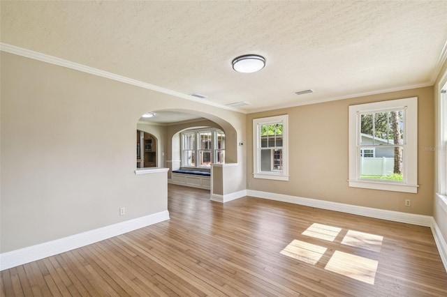 524 S Lakeview Ave, Winter Garden, FL 34787 - empty room with arched walkways, light wood-style floors, crown molding, and a textured ceiling
