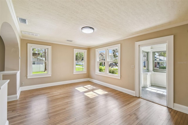 524 S Lakeview Ave, Winter Garden, FL 34787 - empty room with light wood-style floors, plenty of natural light, a textured ceiling, arched walkways, and crown molding