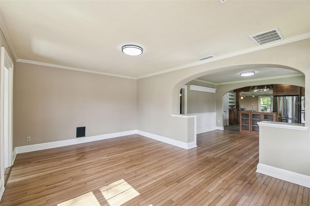524 S Lakeview Ave, Winter Garden, FL 34787 - unfurnished living room with light wood finished floors, arched walkways, and crown molding