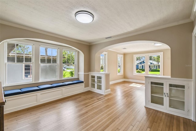 524 S Lakeview Ave, Winter Garden, FL 34787 - spare room with light wood-style floors, ornamental molding, plenty of natural light, arched walkways, and a textured ceiling