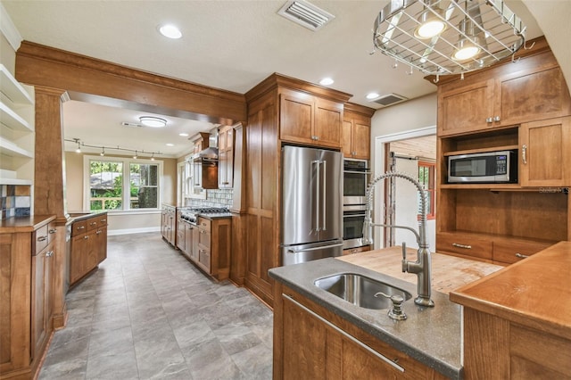 524 S Lakeview Ave, Winter Garden, FL 34787 - kitchen with stainless steel appliances, brown cabinetry, open shelves, backsplash, and wall chimney exhaust hood