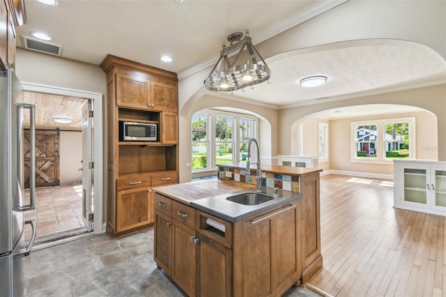 524 S Lakeview Ave, Winter Garden, FL 34787 - kitchen with stainless steel appliances, arched walkways, an island with sink, ornamental molding, and healthy amount of natural light