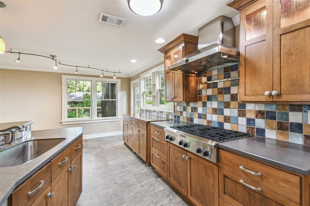 524 S Lakeview Ave, Winter Garden, FL 34787 - kitchen with wall chimney exhaust hood, stainless steel gas cooktop, brown cabinetry, backsplash, and recessed lighting