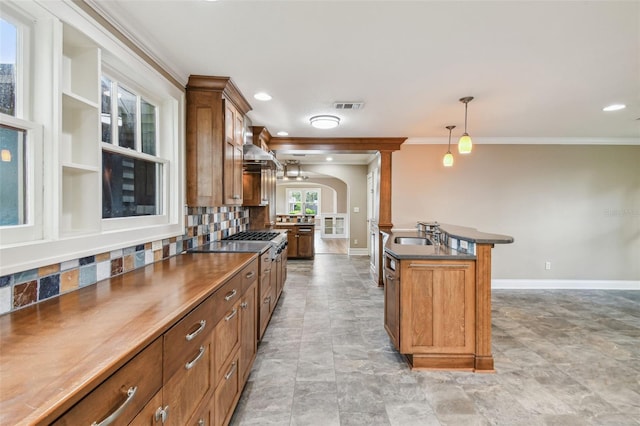 524 S Lakeview Ave, Winter Garden, FL 34787 - kitchen with ornamental molding, dark countertops, decorative backsplash, brown cabinets, and pendant lighting