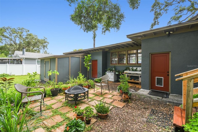 524 S Lakeview Ave, Winter Garden, FL 34787 - rear view of property with a fire pit, a patio area, stucco siding, and a sunroom