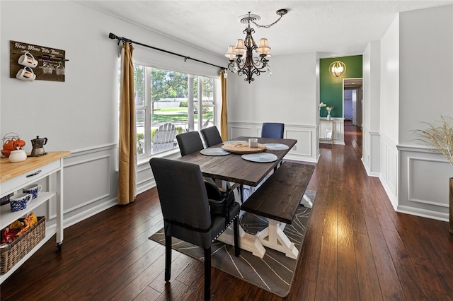 2220 Derbyshire Rd, Maitland, FL 32751 - dining area with a chandelier, a decorative wall, dark wood-type flooring, and wainscoting