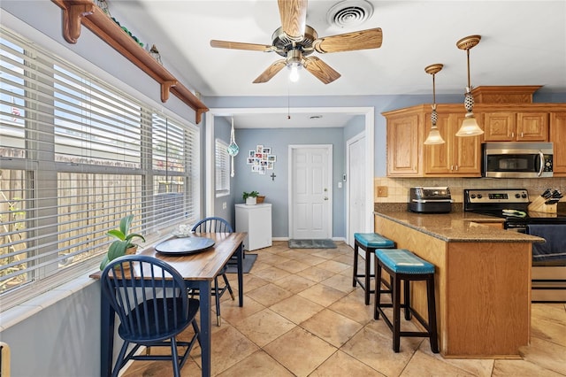 2220 Derbyshire Rd, Maitland, FL 32751 - kitchen with appliances with stainless steel finishes, decorative backsplash, a ceiling fan, a breakfast bar area, and pendant lighting