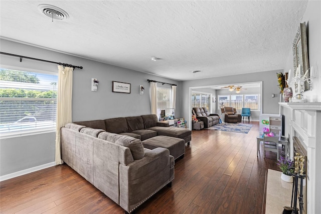 2220 Derbyshire Rd, Maitland, FL 32751 - living area featuring a textured ceiling, hardwood / wood-style floors, a ceiling fan, and a fireplace with flush hearth