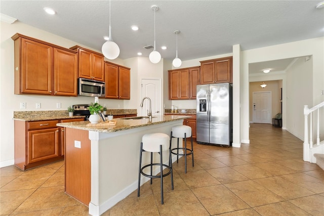 7409 Fairgrove Ave, Windermere, FL 34786 - kitchen with appliances with stainless steel finishes, brown cabinets, a kitchen breakfast bar, an island with sink, and recessed lighting