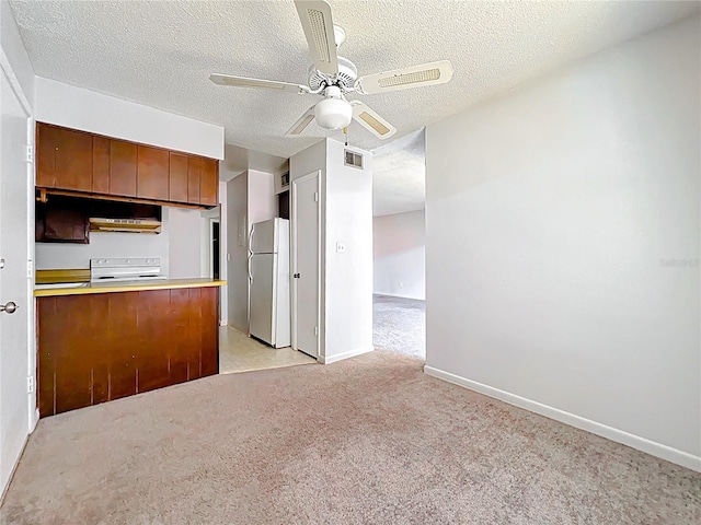 200 St Andrews Blvd Unit 911, Winter Park, FL 32792 - kitchen featuring freestanding refrigerator, stove, brown cabinets, light colored carpet, and a ceiling fan