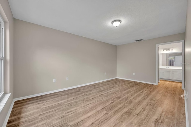 557 Hunter Cir, Kissimmee, FL 34758 - unfurnished room with light wood finished floors and a textured ceiling