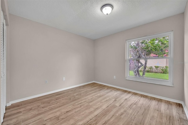 557 Hunter Cir, Kissimmee, FL 34758 - unfurnished room featuring light wood-style flooring and a textured ceiling