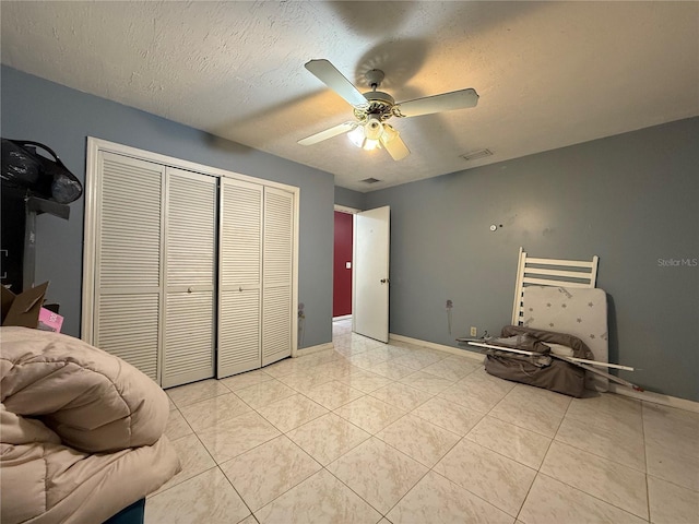 831 Fletcher Rd SE, Palm Bay, FL 32909 - unfurnished bedroom featuring a closet, a textured ceiling, a ceiling fan, and light tile patterned floors