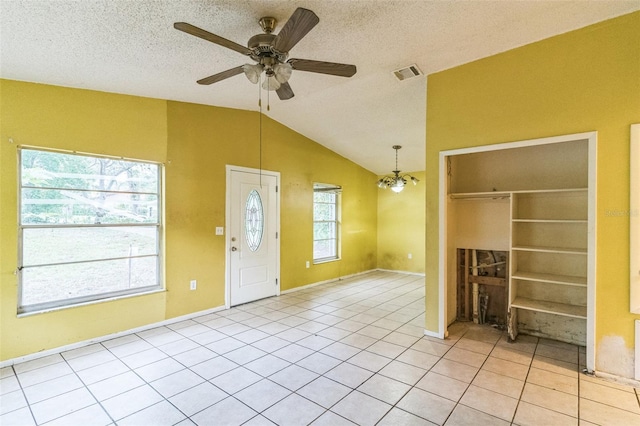 1212 N Hudson St, Orlando, FL 32808 - foyer entrance featuring vaulted ceiling, ceiling fan, light tile patterned flooring, a chandelier, and a textured ceiling