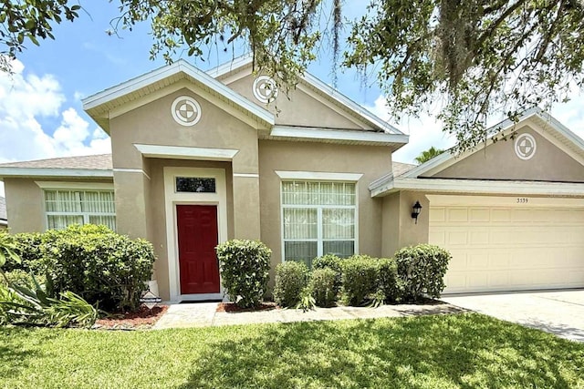 3539 Maple Ridge Loop, Kissimmee, FL 34741 - view of front of house featuring stucco siding, a garage, a front lawn, and concrete driveway