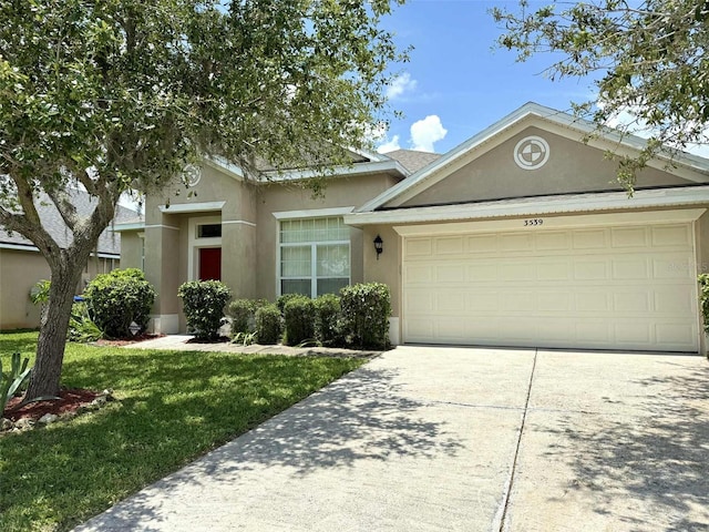 3539 Maple Ridge Loop, Kissimmee, FL 34741 - view of front of home with an attached garage, stucco siding, concrete driveway, and a front lawn