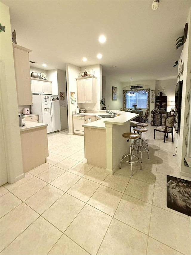 3539 Maple Ridge Loop, Kissimmee, FL 34741 - kitchen with a peninsula, white fridge with ice dispenser, light countertops, recessed lighting, and a kitchen bar
