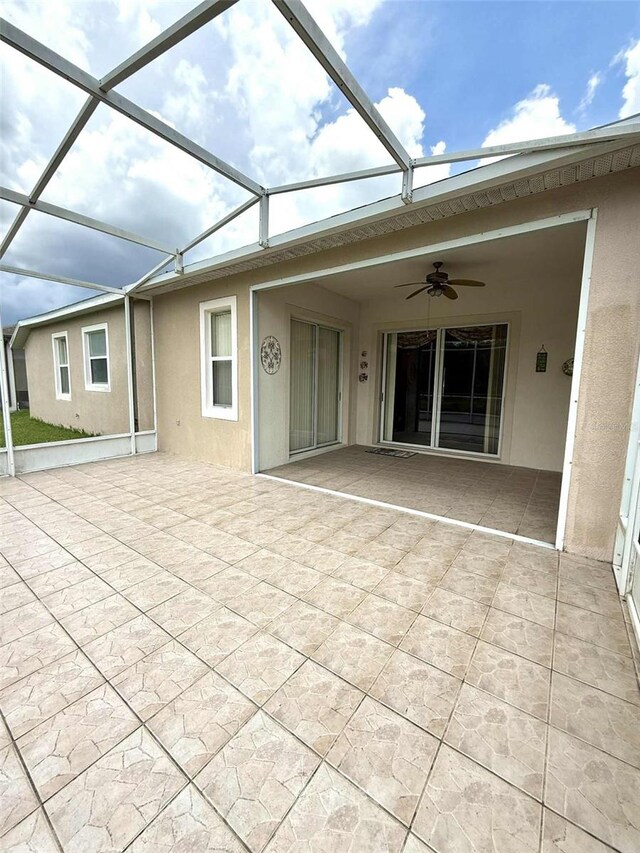 3539 Maple Ridge Loop, Kissimmee, FL 34741 - back of property with a ceiling fan, a patio, stucco siding, and glass enclosure