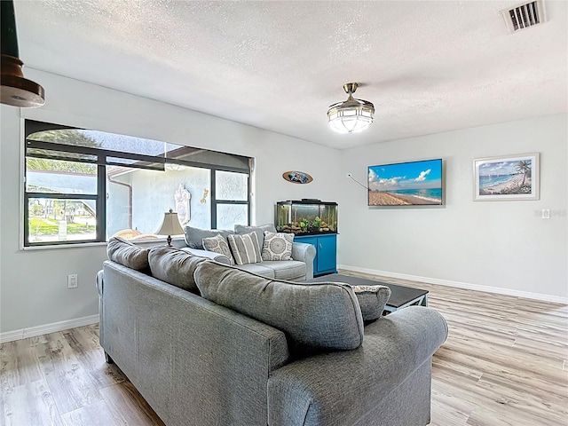 1475 Mars St, Merritt Island, FL 32953 - living area featuring a textured ceiling, plenty of natural light, and light wood finished floors