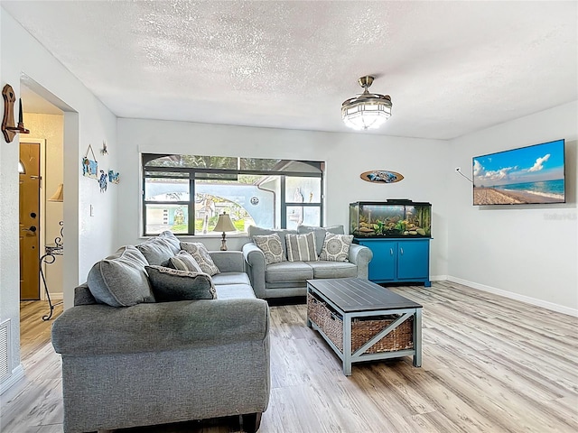 1475 Mars St, Merritt Island, FL 32953 - living area with healthy amount of natural light, light wood-style floors, and a textured ceiling