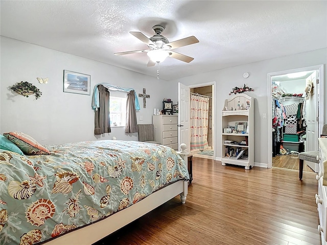 1475 Mars St, Merritt Island, FL 32953 - bedroom featuring a spacious closet, wood finished floors, a textured ceiling, a closet, and a ceiling fan