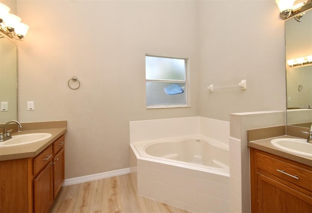 2131 Kaylas Ct, Orlando, FL 32817 - bathroom with two vanities, a bath, and wood finished floors