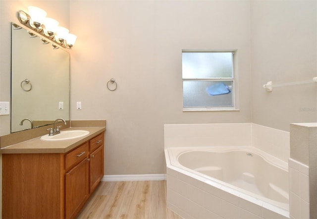 2131 Kaylas Ct, Orlando, FL 32817 - full bathroom featuring vanity, a garden tub, and wood finished floors