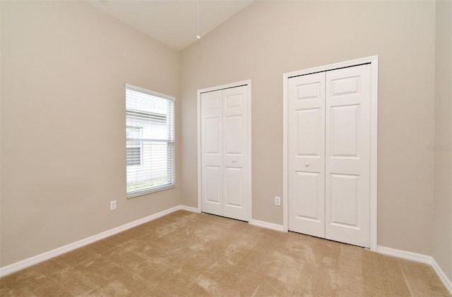 2131 Kaylas Ct, Orlando, FL 32817 - unfurnished bedroom with two closets, light colored carpet, and high vaulted ceiling