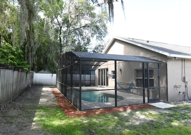 2131 Kaylas Ct, Orlando, FL 32817 - rear view of property featuring a fenced backyard, glass enclosure, a patio, and stucco siding