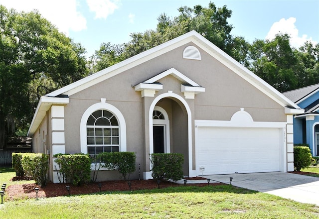2131 Kaylas Ct, Orlando, FL 32817 - view of front of house with a garage, driveway, a front lawn, and stucco siding
