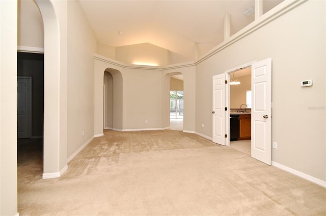 2131 Kaylas Ct, Orlando, FL 32817 - empty room with arched walkways, light carpet, a chandelier, and a high ceiling