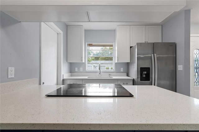 1066 Swanson Dr, Deltona, FL 32738 - kitchen featuring stainless steel fridge with ice dispenser, light stone countertops, black electric cooktop, and white cabinets