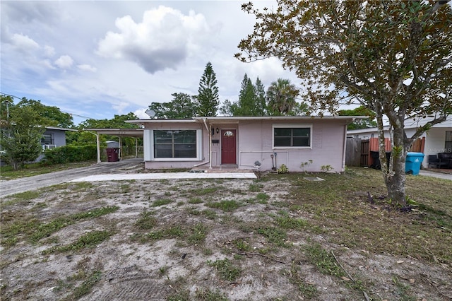 535 Romano Ave, Orlando, FL 32807 - view of front of property with concrete block siding, an attached carport, and driveway