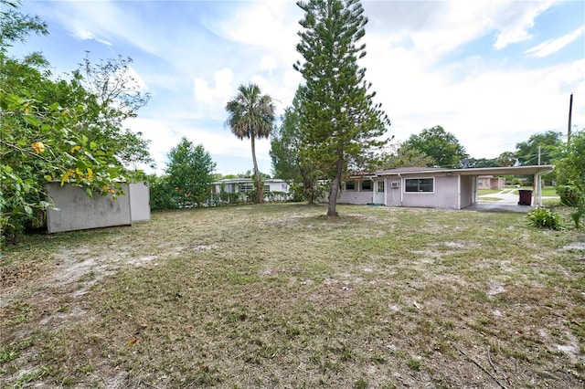535 Romano Ave, Orlando, FL 32807 - view of grassy yard with a storage unit and a carport