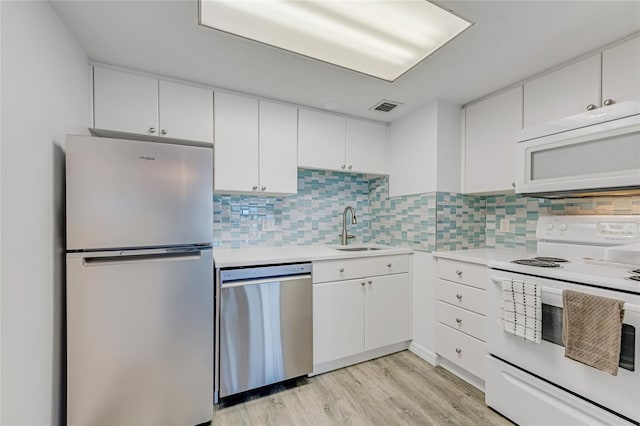 2700 Ocean Shore Blvd Unit 515, Ormond Beach, FL 32176 - kitchen with appliances with stainless steel finishes, light countertops, light wood-type flooring, and white cabinetry