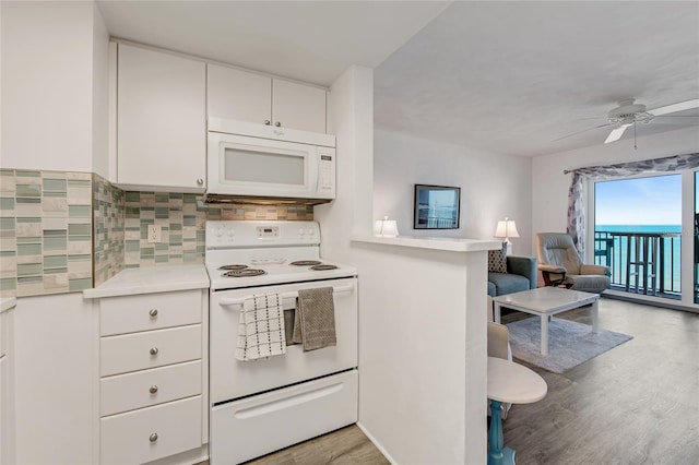 2700 Ocean Shore Blvd Unit 515, Ormond Beach, FL 32176 - kitchen featuring white appliances, light wood-type flooring, tasteful backsplash, ceiling fan, and white cabinets