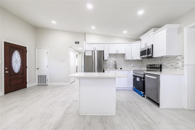 226 Palmyra Dr, Orlando, FL 32807 - kitchen with appliances with stainless steel finishes, lofted ceiling, backsplash, light countertops, and a kitchen island