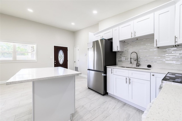 226 Palmyra Dr, Orlando, FL 32807 - kitchen with freestanding refrigerator, tasteful backsplash, a center island, white cabinetry, and recessed lighting